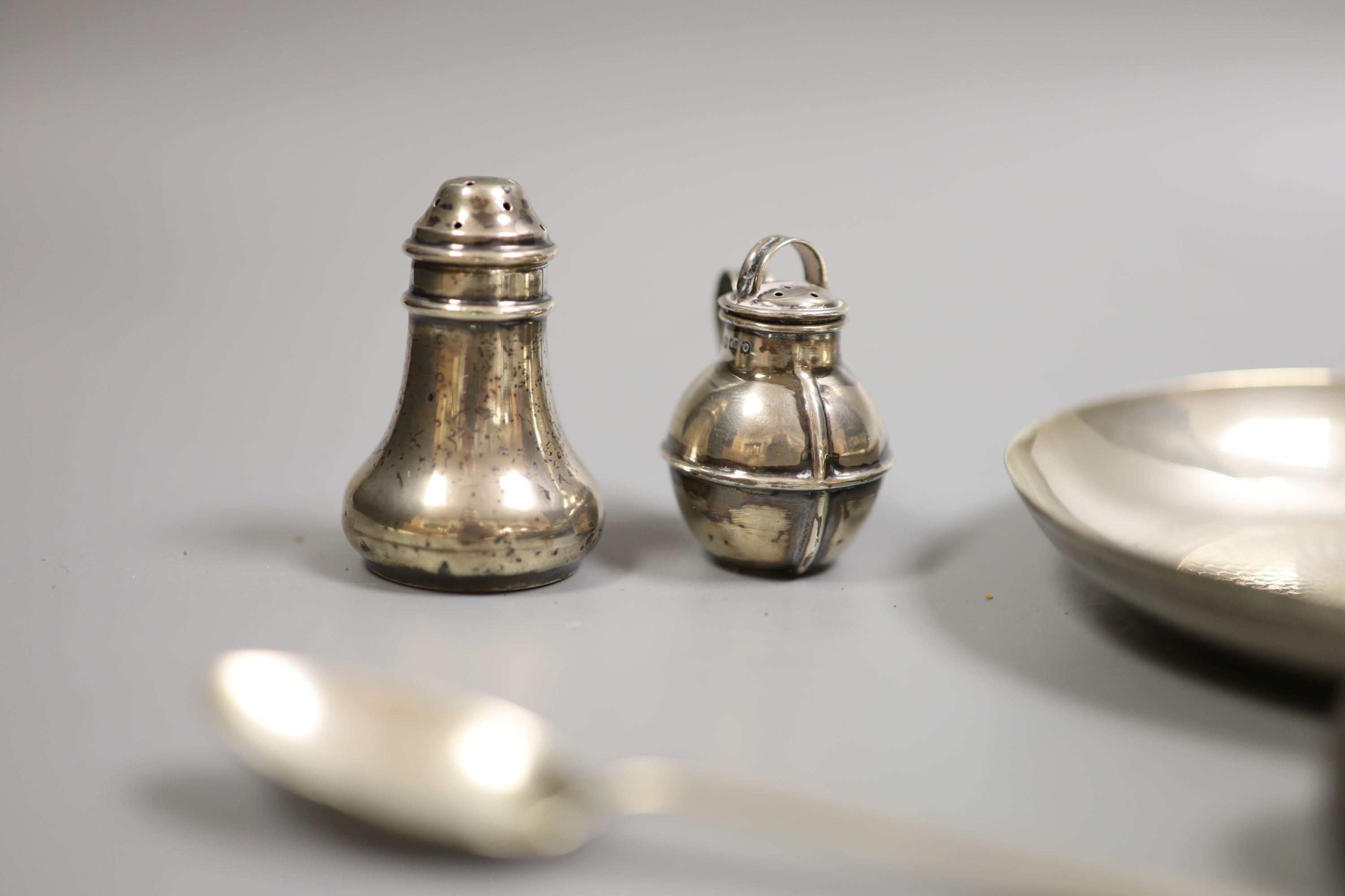 A Persian white metal tea cup and saucer and small sile items including two pepperettes, a trinket box and assorted minor flatware